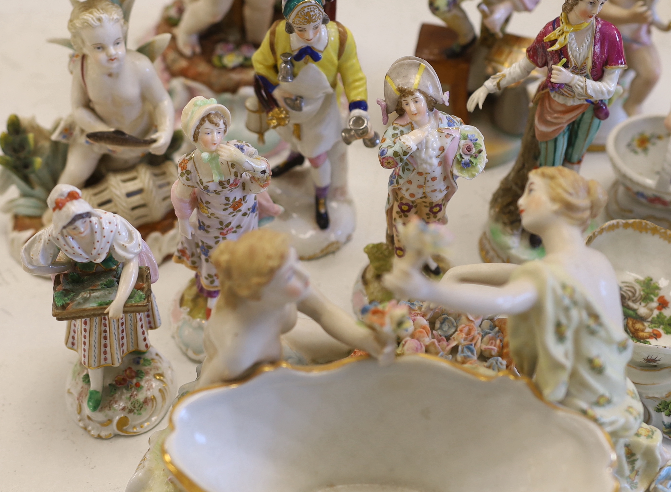 A collection of Continental porcelain figures, candleholders, table centres, some marked ‘AR’, cherubs, lovers, salesmen, tallest 20.5cm (15)